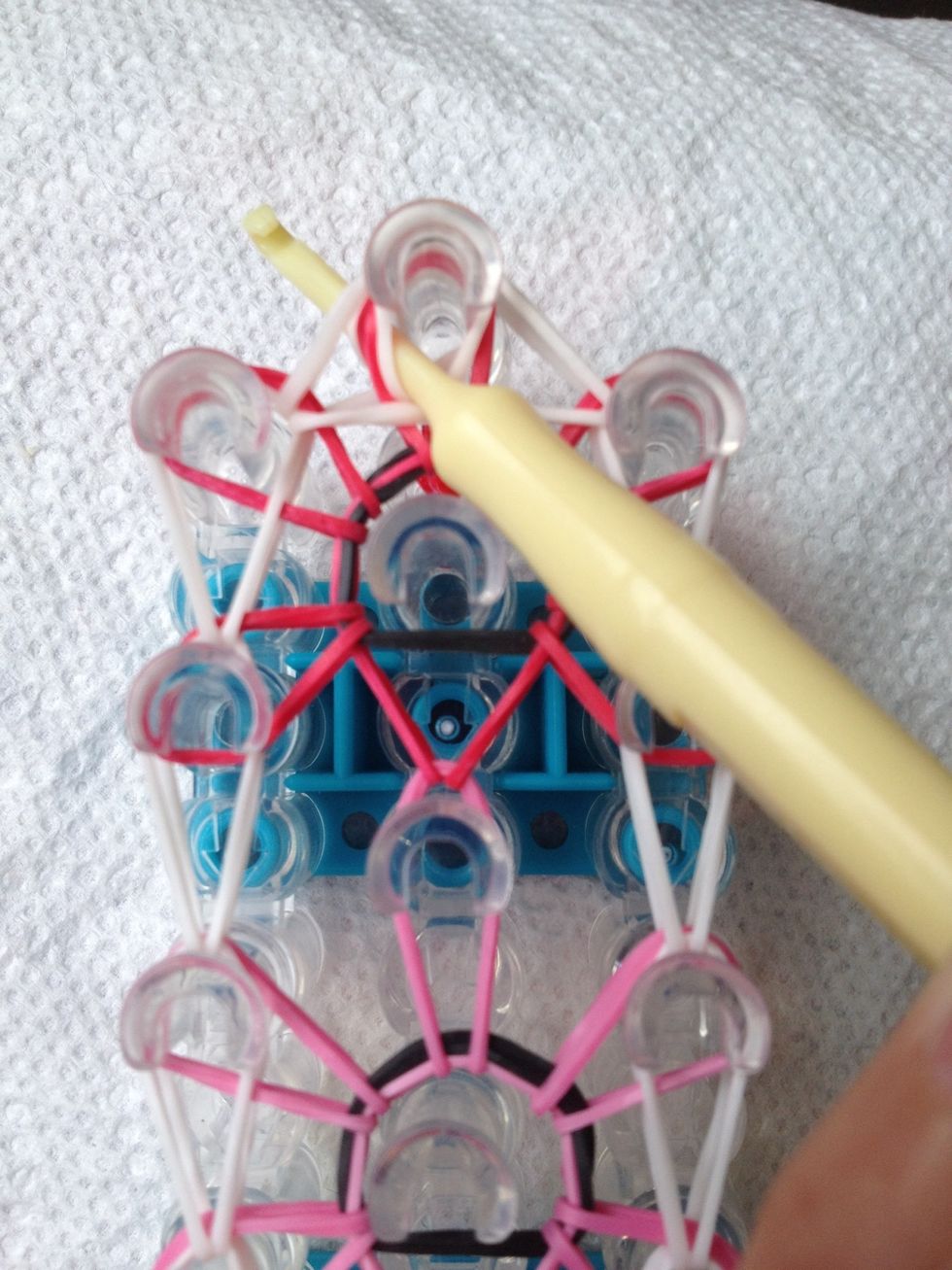 Put the hook through the peg at the top of the loom catch all the bands!