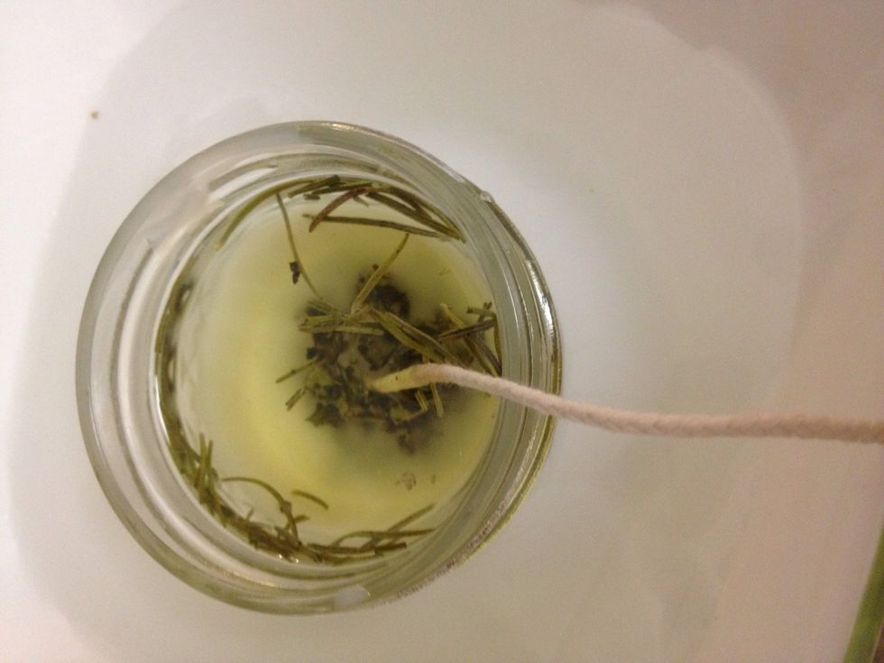 Put the jar into a bowl with cold water & ice while still holding the wick up. As the wax begins to harden at the bottom, you can let the wick rest on the side, occasionally pulling the wick straight.