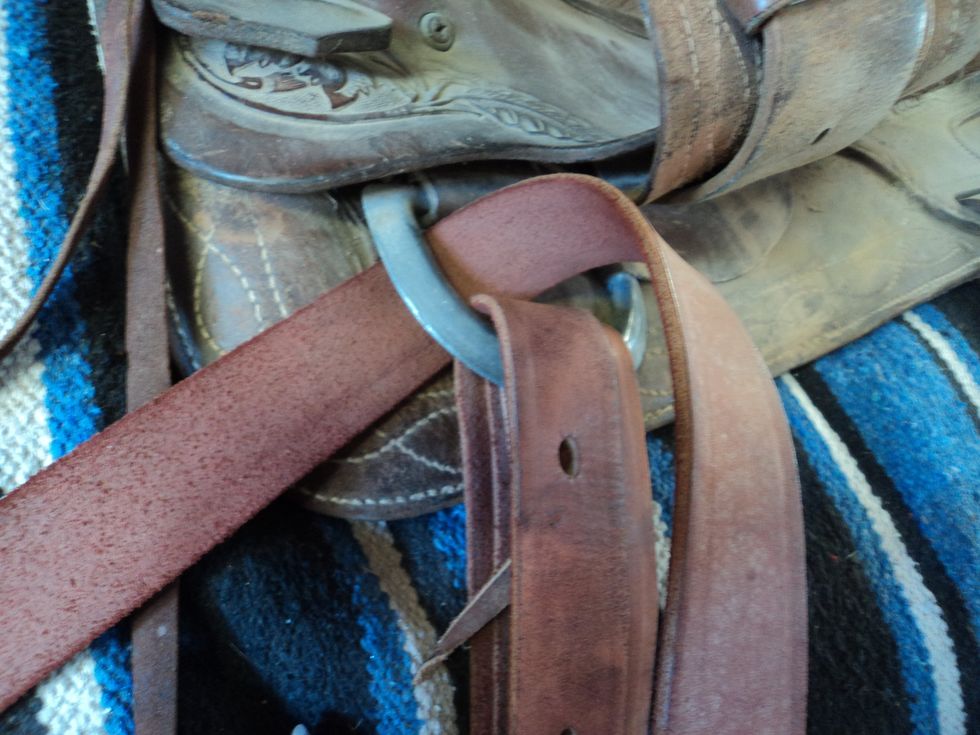 Put the latigo strap around the front rigging dee to the left.