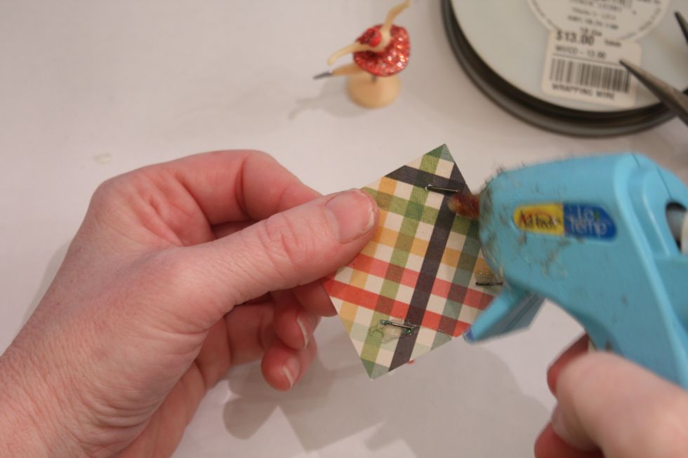 Put the little "L's" through the bottom of the holes you punched and hot glue them down. TIP: You can use the hot tip of your glue gun to smooth out and make glue as flat as possible.