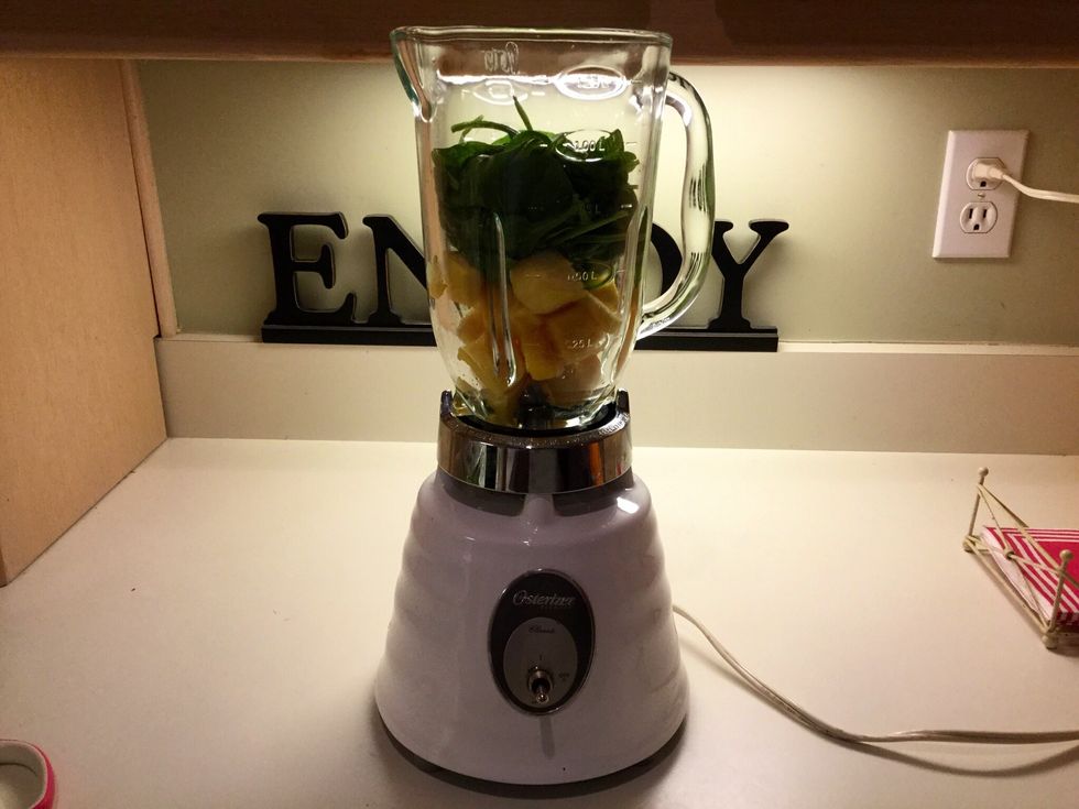 Put the measured mango and spinach into the blender