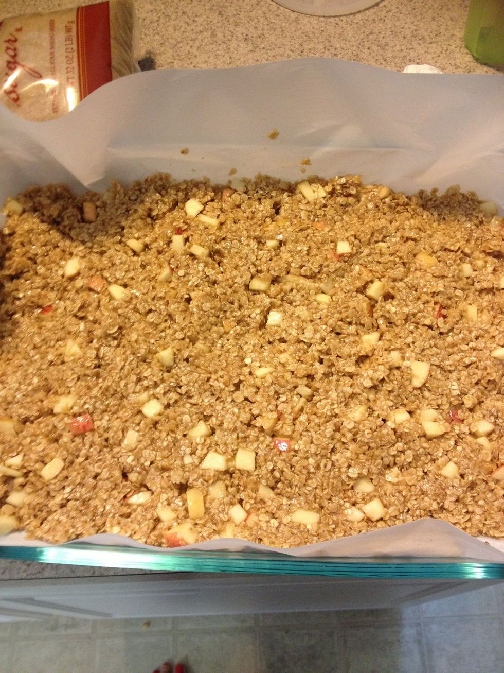 Put the mixture in a large pan lined with parchment paper. Spread it evenly into the pan. Remember you will be cutting them later so you don't want them to be to thick.