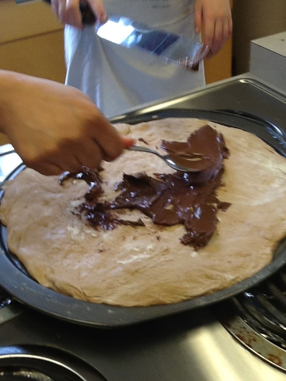 Put the Nutella on the pizza dough and spread the Nutella.