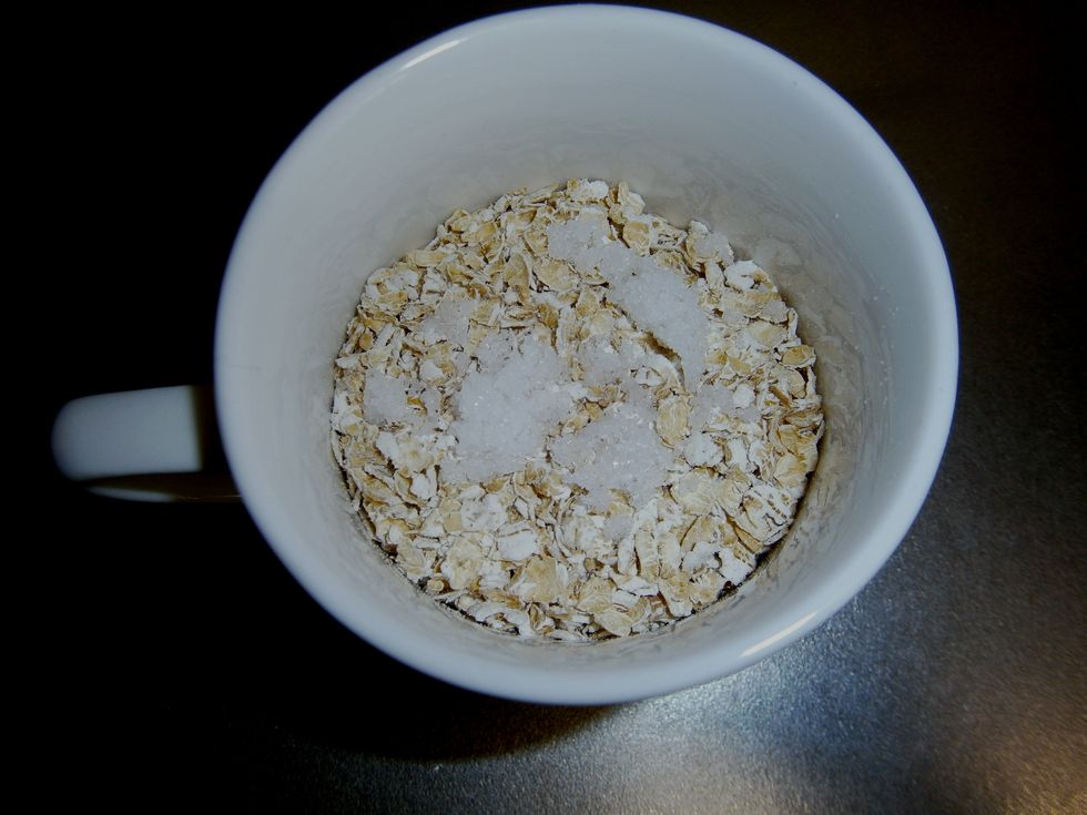 Put the oats in a cup. One serving for me would be 3/4 of a cup. The white bits are salt. Some people like to put sugar in porridge, but I prefer to do it the Scottish way with salt.
