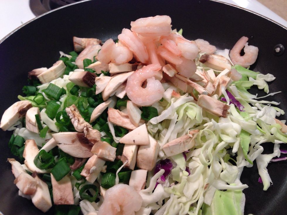 Put the oil, cole slaw, shrimp, mushroom, ginger, and spring onions in a skillet.
