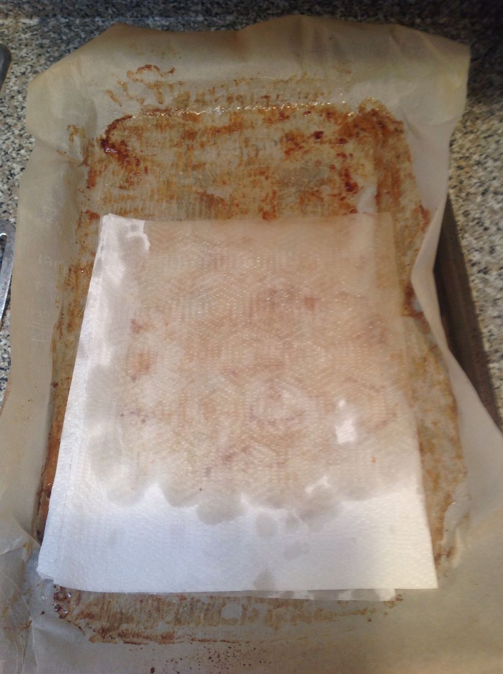 Put the paper towel in the middle of the parchment and roll it up into an envelope. Now just put the wrap in the garbage. Put the tray back in the cupboard. There's nothing left to clean.