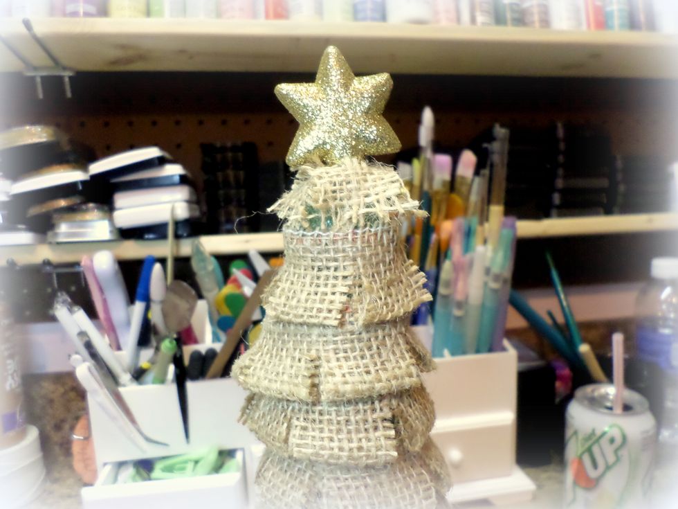 Put the part of the star where the hanging part was into the hole in the top of the tree.