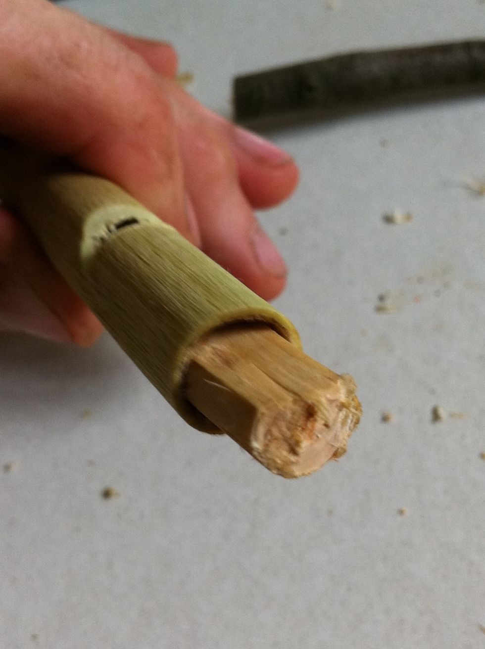 Put the piece you just cut in the front of your whistle, it's ok if you can see it appear through the v shaped hole.