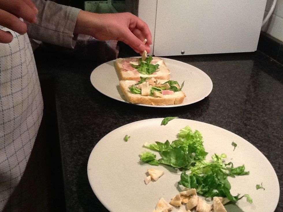 Put the pieces of lettuce and chicken in the two slices.