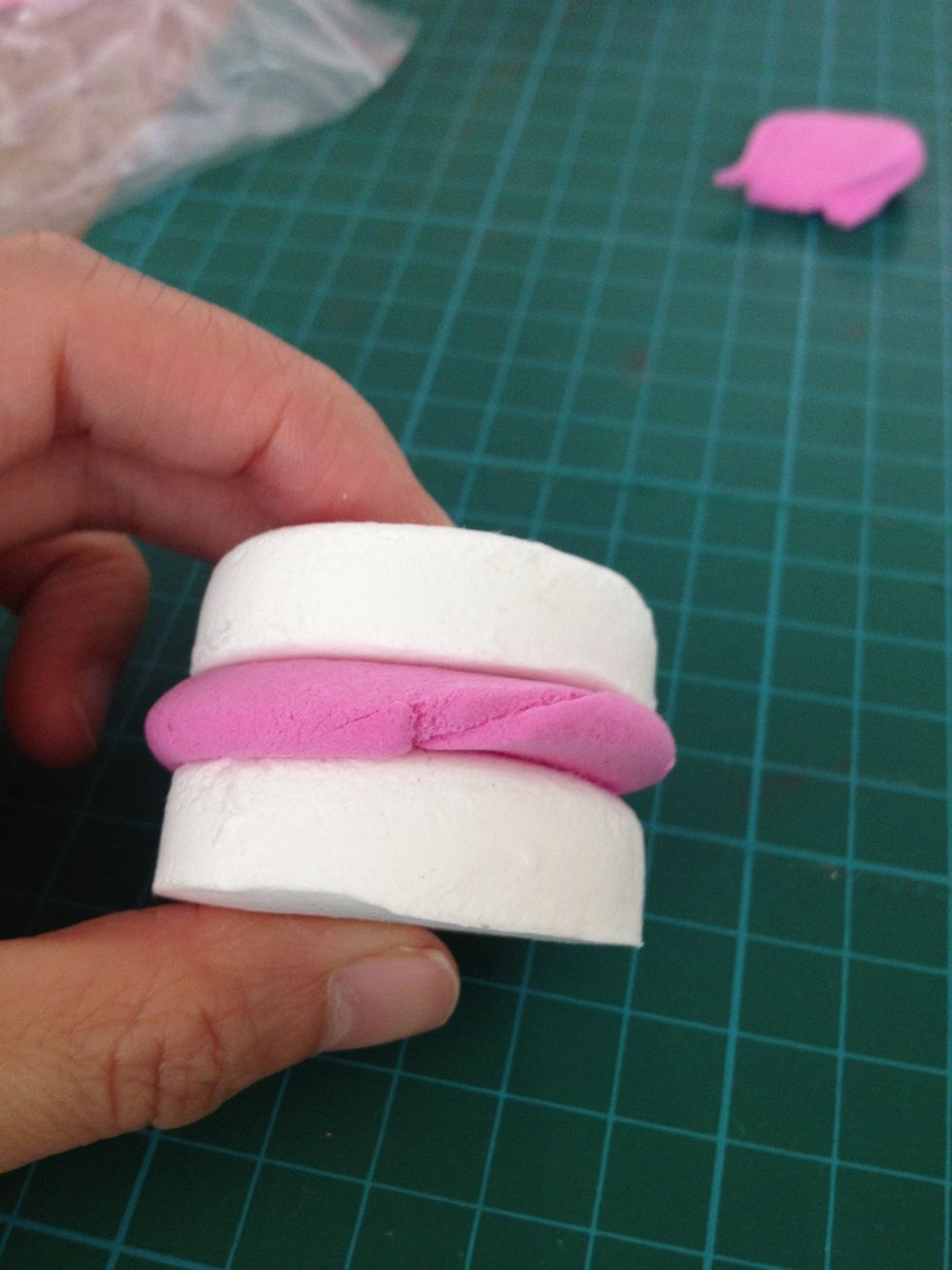 Put the pink clay in-between the 2 pieces of white circle clay.