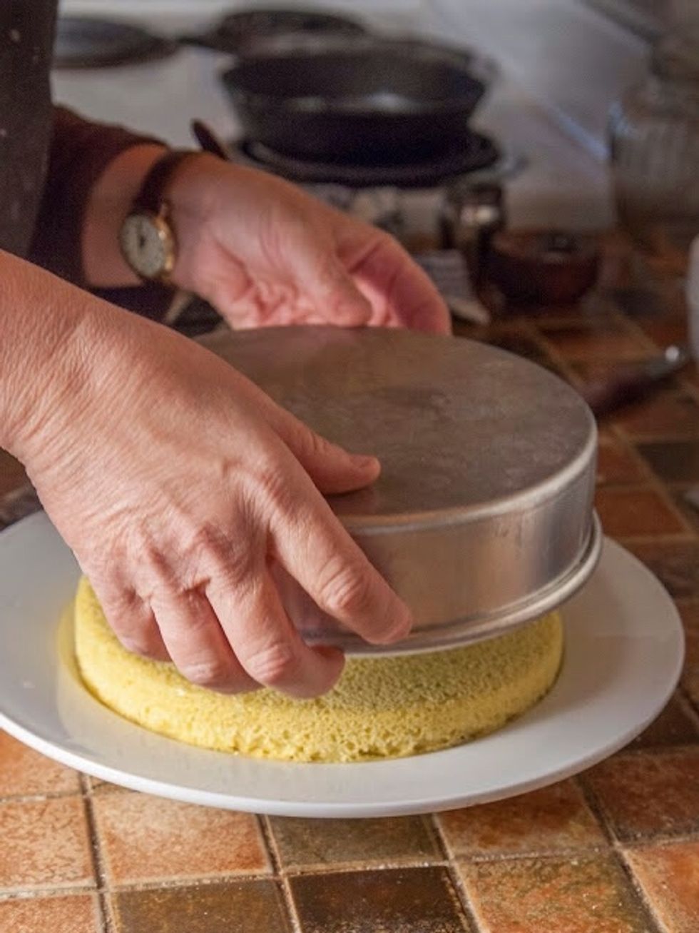Put the plate onto the top of the cake pan and turn it upside down. It will unmold.