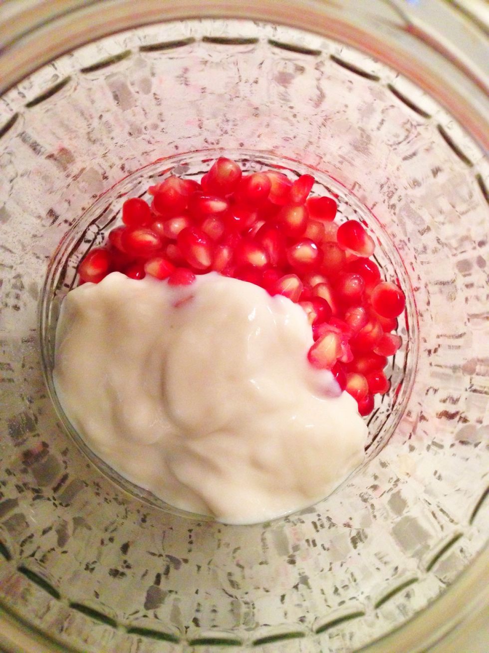 Put the pomegranate seeds and soy yogurt into a jar.