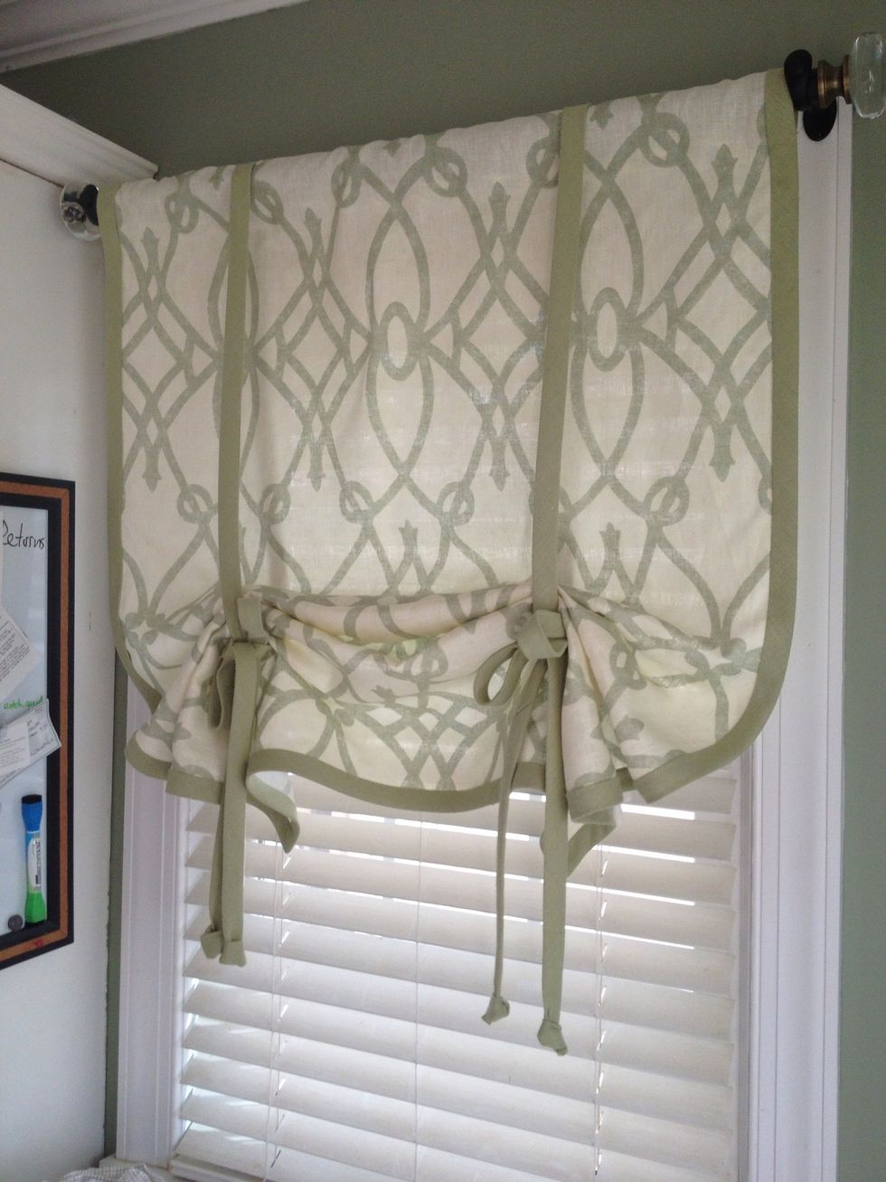 Put the rod through the header at the top of the shade and place the rod in the brackets you installed earlier. Pull the shade up to the desired length and tie a bow. Adjust the folds