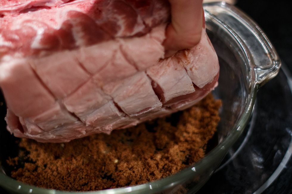 Put the rub in a dish and press the scored side of the meat onto it.