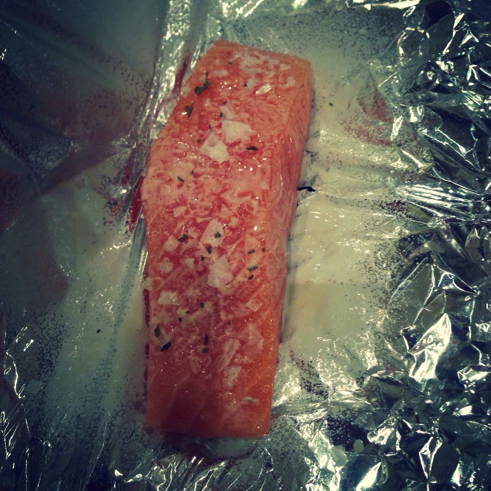 Put the salmon fillet on the foil. Spray with fry light, add a pinch of garlic sea salt. Put foil around the fillet and close.
