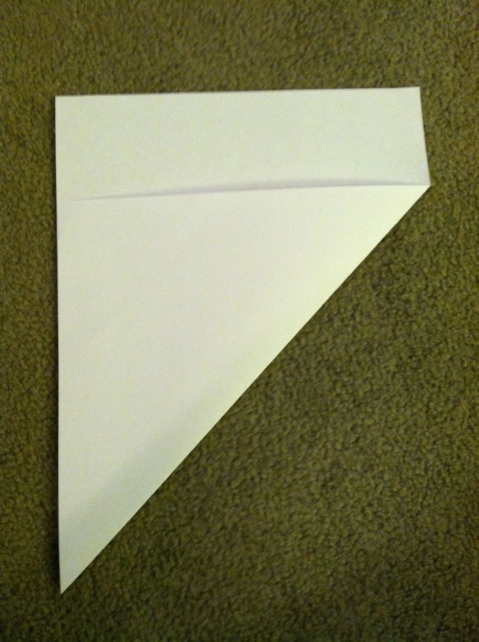 Put the short side of the paper facing you and fold the bottom right corner up to the left until it forms a triangle with the left side.