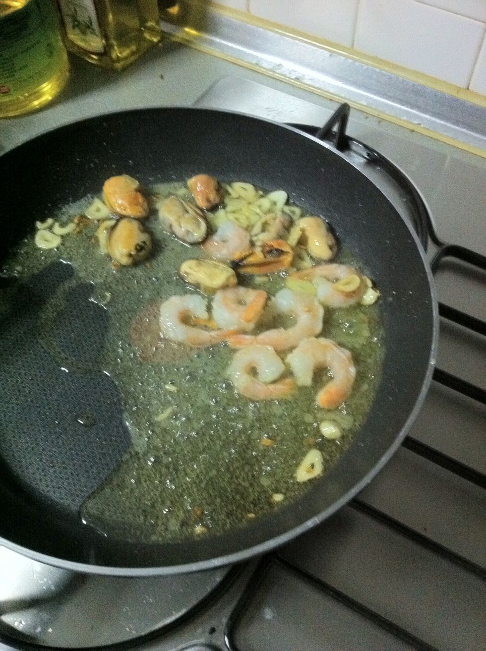 Put the shrimps (skin removed except the tail) and mussels (no shells) in the pan... I actually use those packed seafood on the frozen section of the grocery.