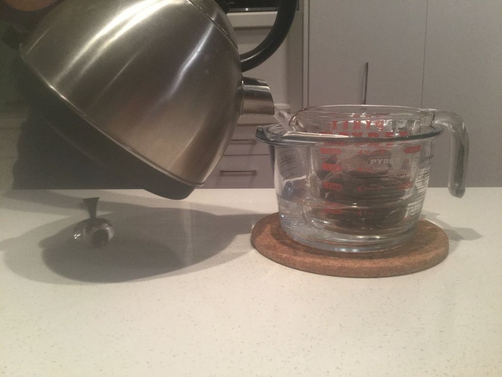 Put the small heatproof jug into a big heatproof jug and pour the boiling water into the big jug. Make sure not to get any water on the chocolate.