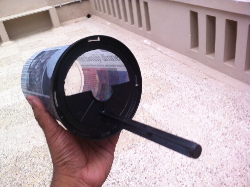 Put the spool back together. Cover the spool with newspaper and tape it so that that it becomes dark from the inside and light doesn't get inside from the "walls" (container). Cover the backside also.