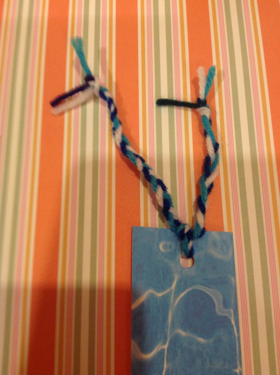 Put the string through the hole and tie a knot