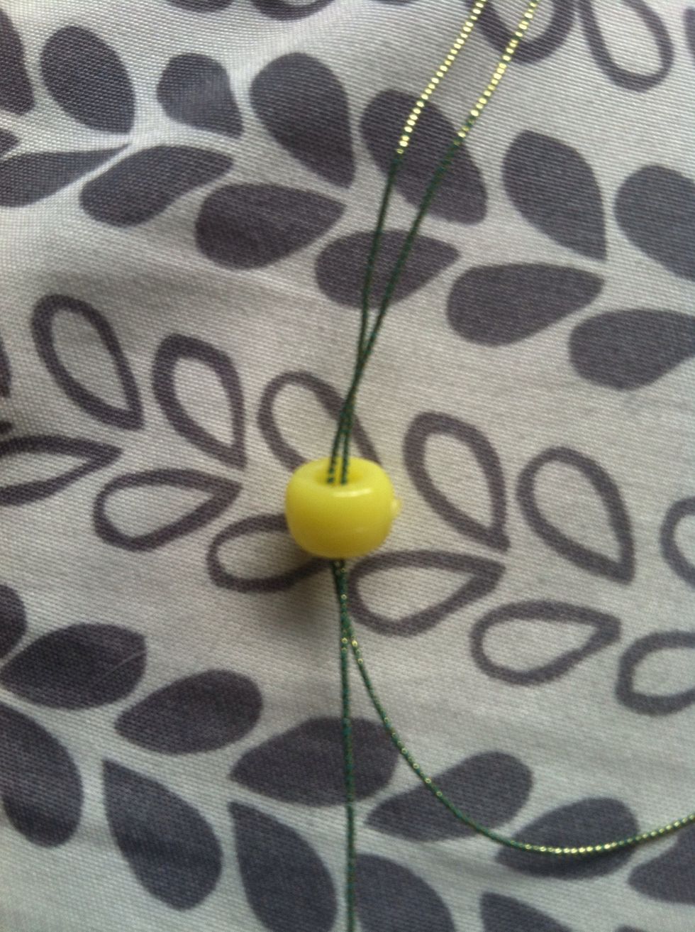 Put the strings together and add a yellow bead.