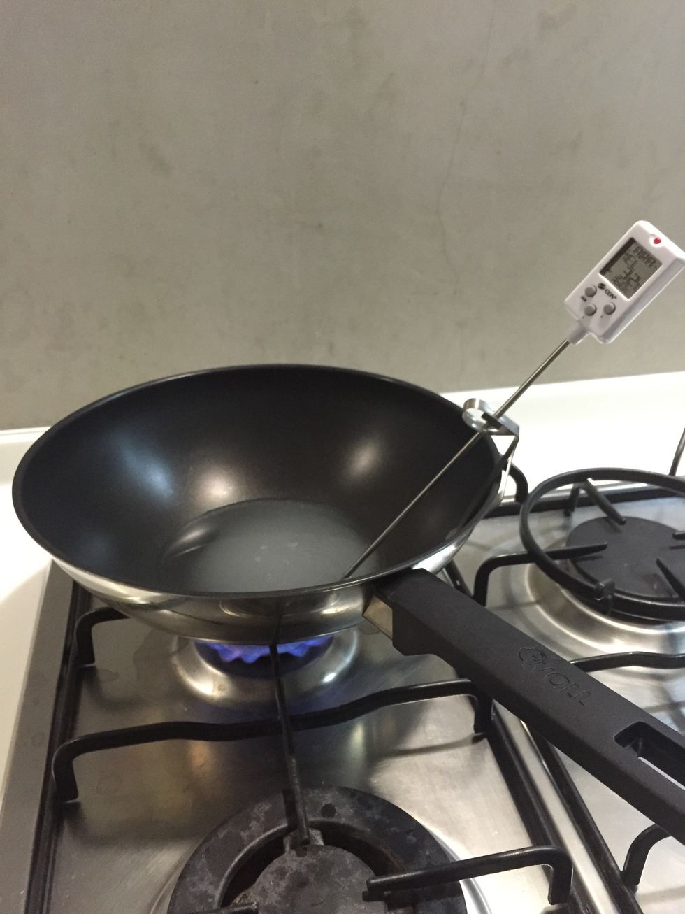 Put the sugar in a wok Set the thermometer in place and put on medium heat.