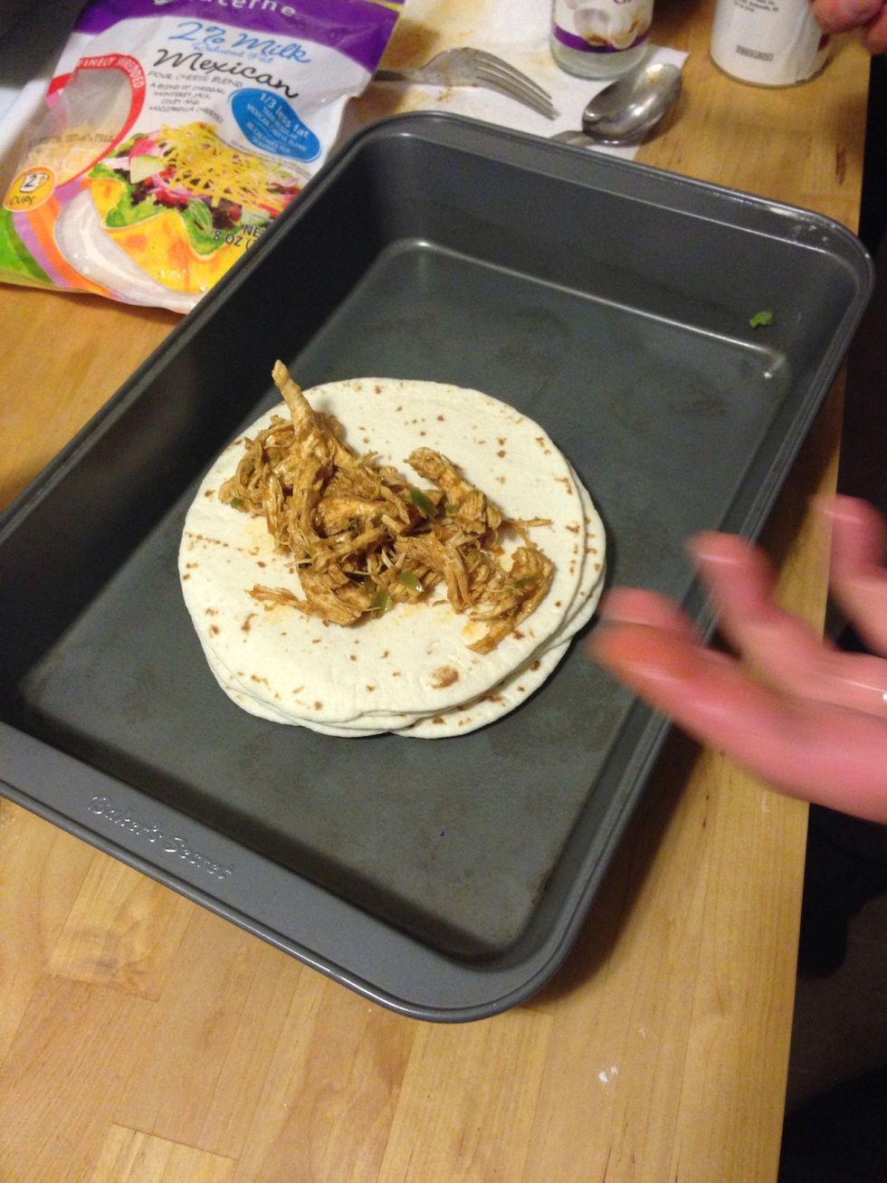 Put the tortillas in a place that will be easy to roll and add the shredded chicken mix.