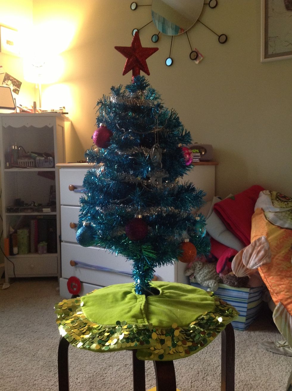 Put the tree skirt around the bottom of the tree.
