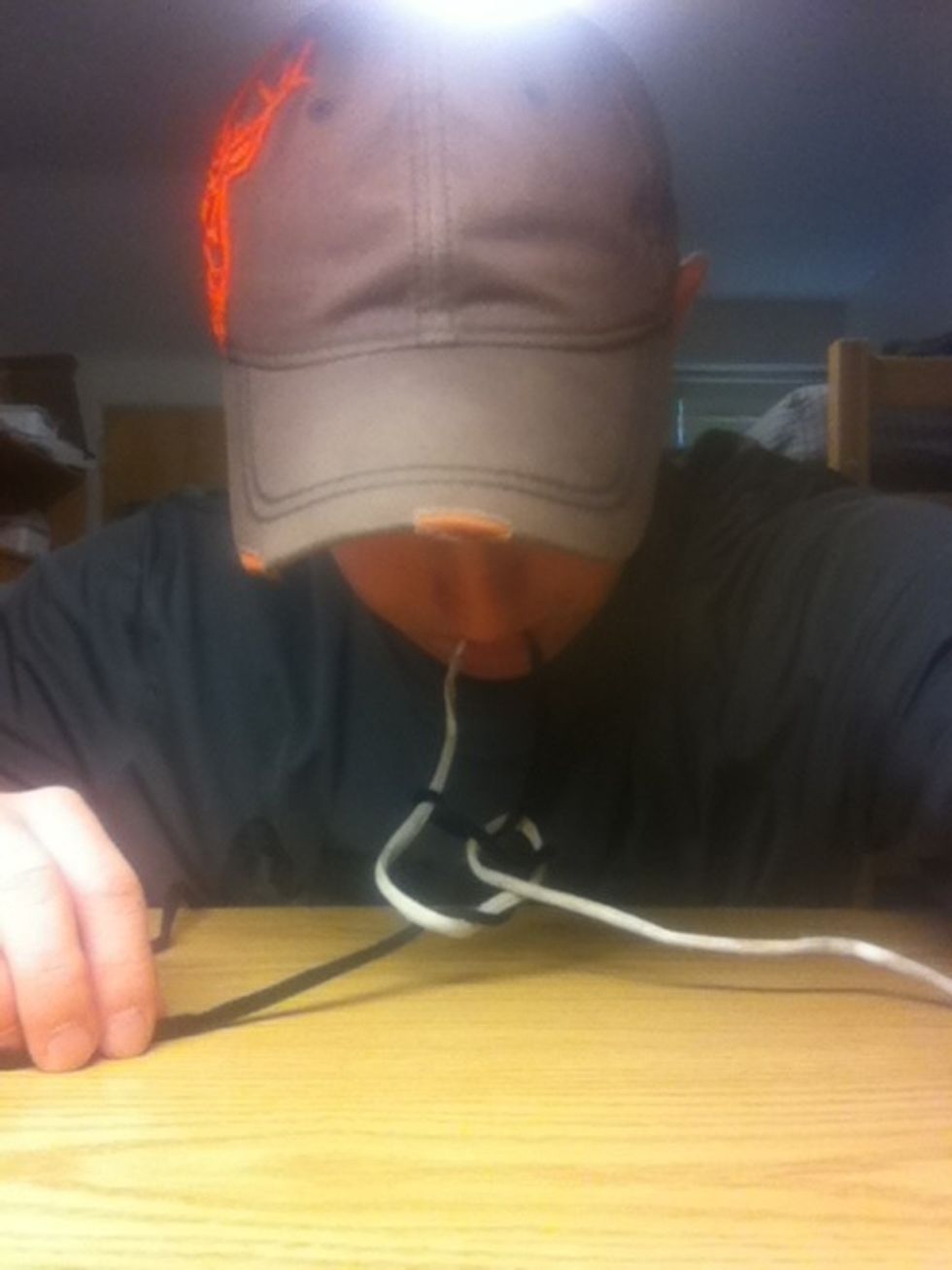 Put the two line ends in your mouth to hold them, then pull the lines tight.