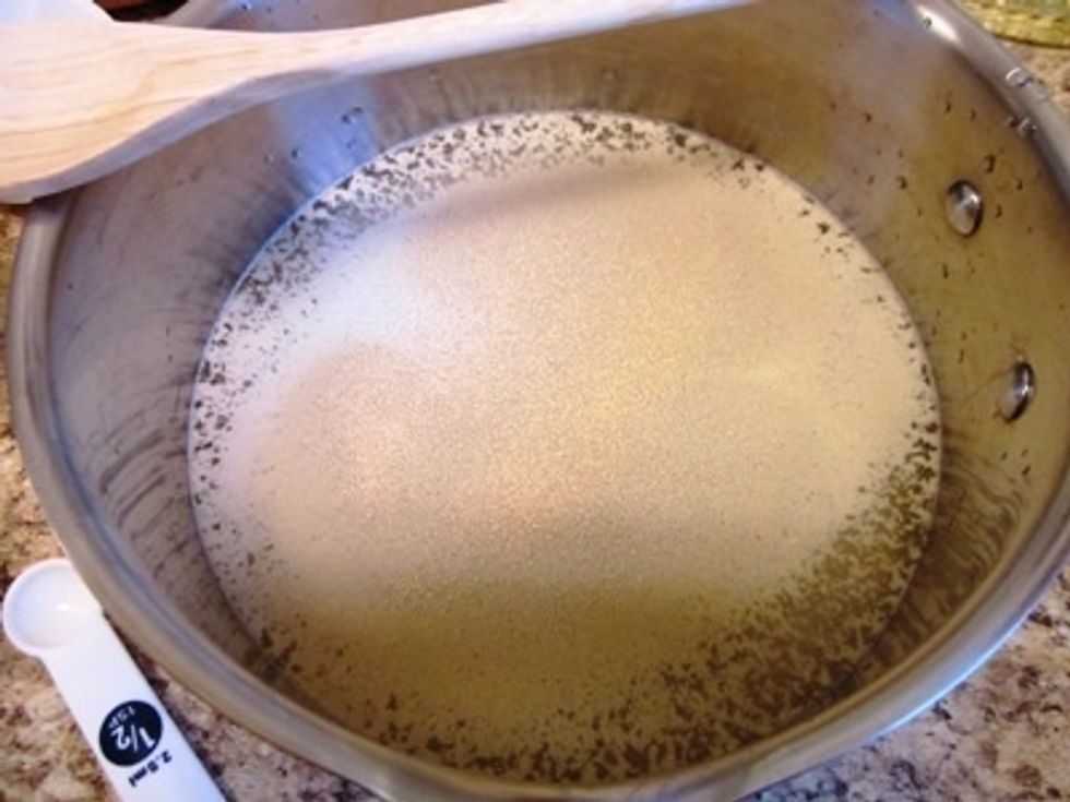 Put the water in your bowl (or pot) and then sprinkle the yeast on top.  You need to let it sit long enough that the yeast is nice and soft.  Then you give it a stir.