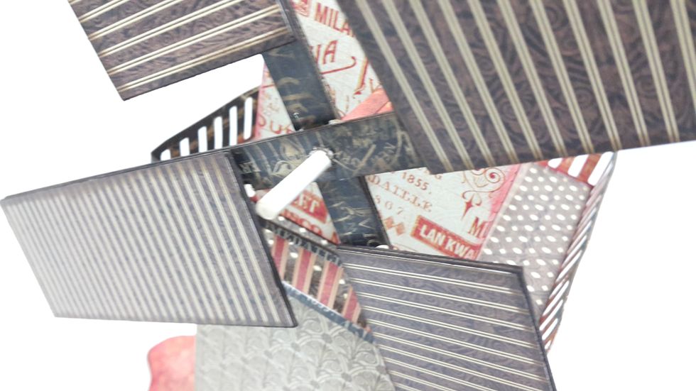 Put the windmill flags through the candy stick and adhere, cut the excess of the stick, adhere a decorative chipboard or other embellishment in the middle to secure.