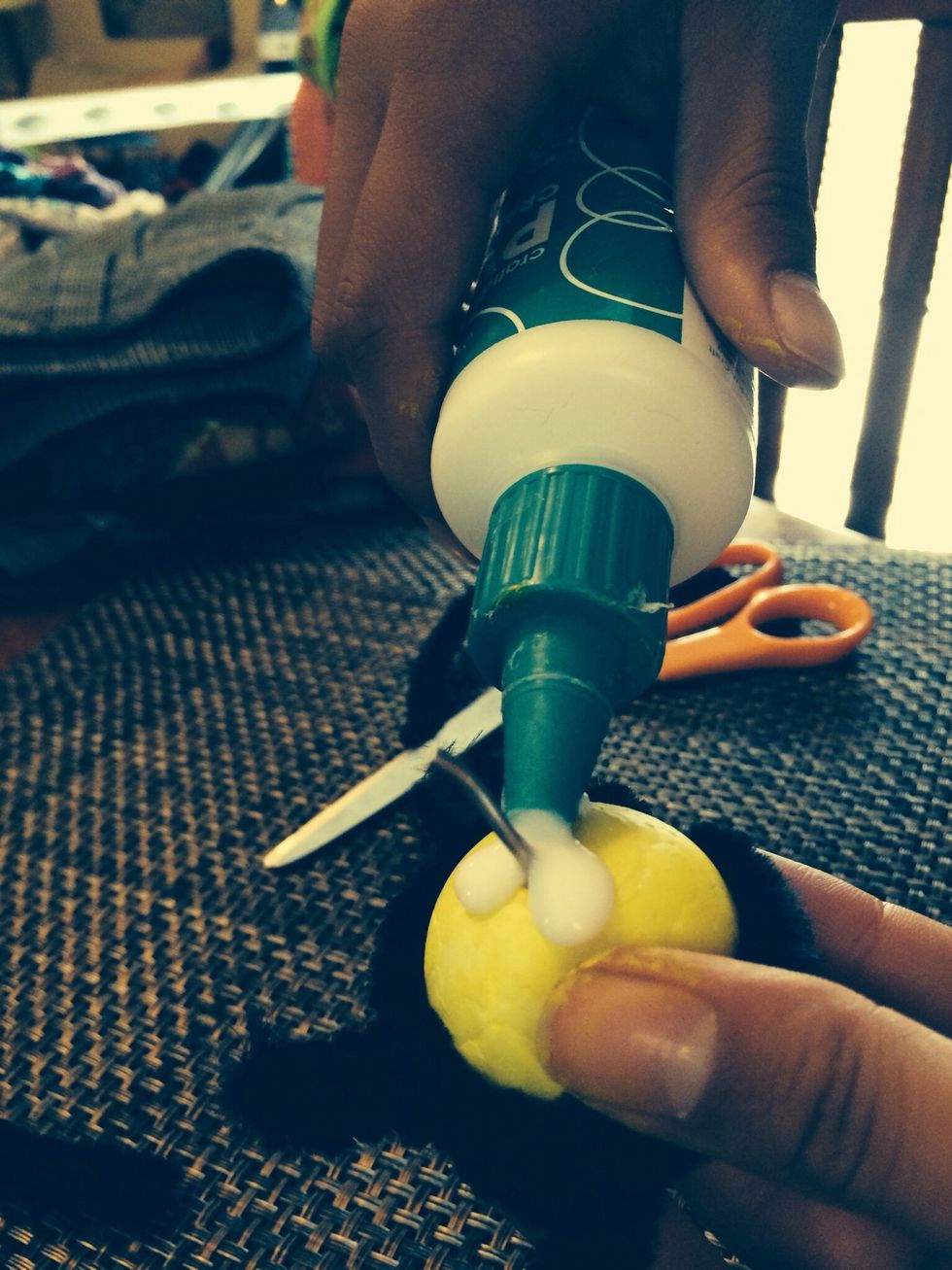 Put the wire into the head of the the bee. Put glue around the wire.