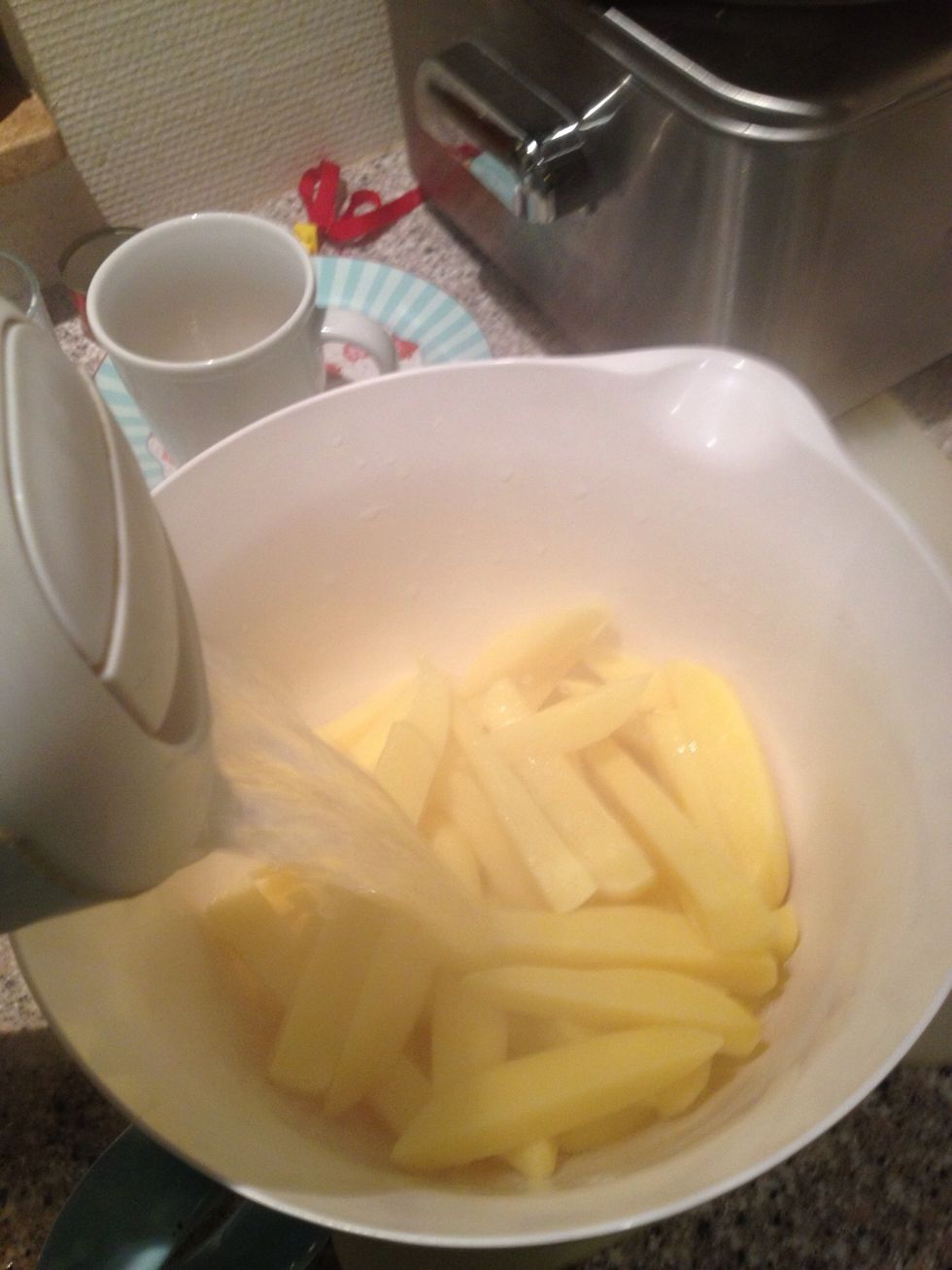 Put them in a big bowl and cover with boiling water. Turn your oven on at 440\u00b0F/225\u00b0C. Let the potatoes sit in the hot water for 20-30 minutes.