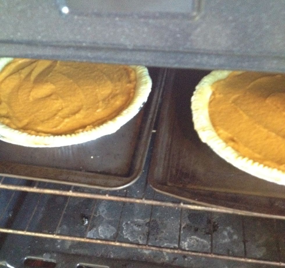 Put them in an oven that's been preheated at 425\u00b0F. After 15 minutes, reduce the heat to 350\u00b0F and cook for approximately 35-45 minutes, until the center of the pie is firm.