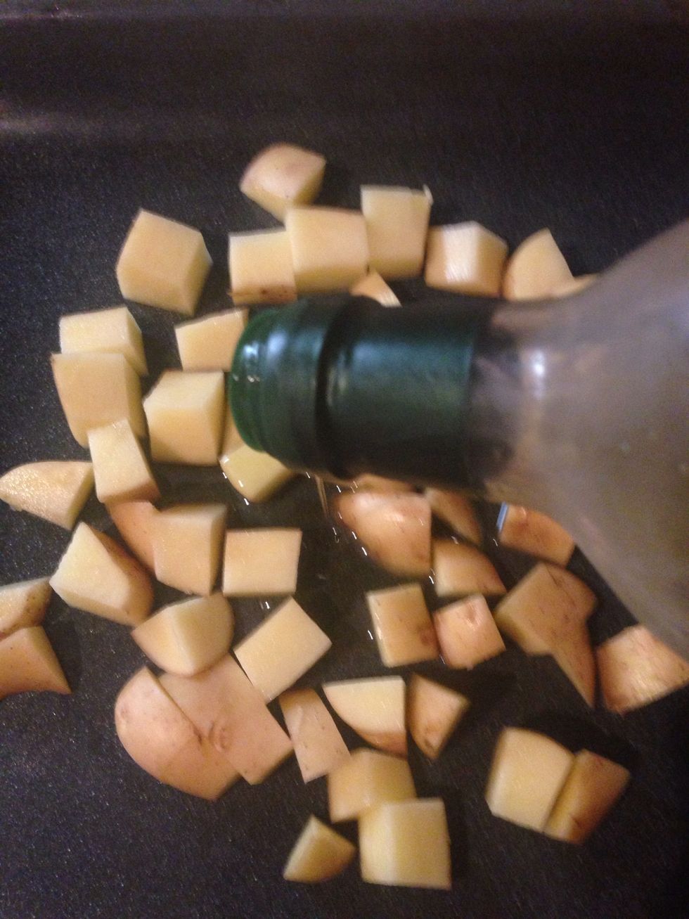 Put them in the oven tray and pour some olive oil over it .