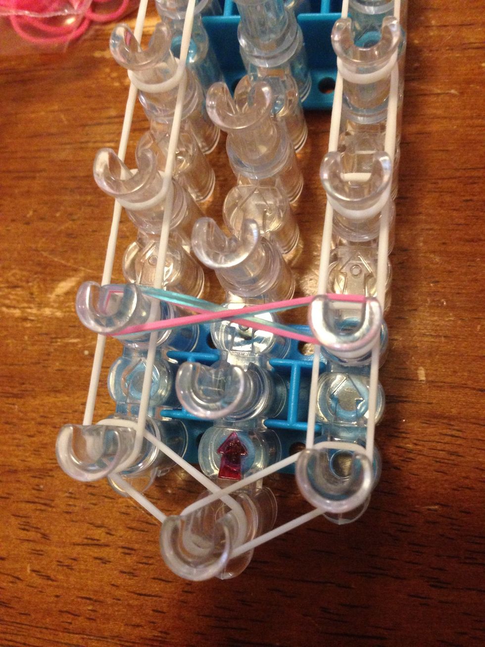 Put them on the second right pin and stretch it to the left one, but twist it once.