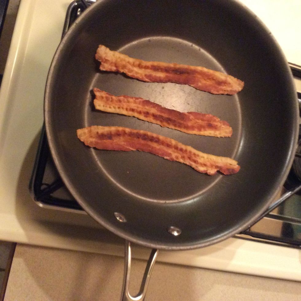 Put three pieces of bacon on the pan