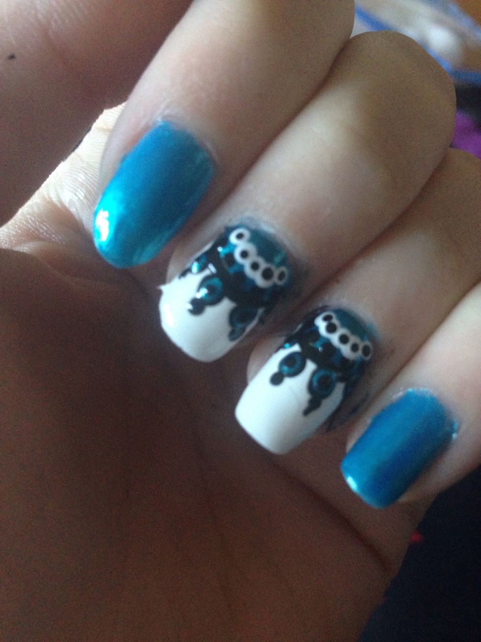 Put tiny black dots inside the white ones, inside the blue bullseye and on the outside of the bullseye. Wait for it to dry completely and add your topcoat!