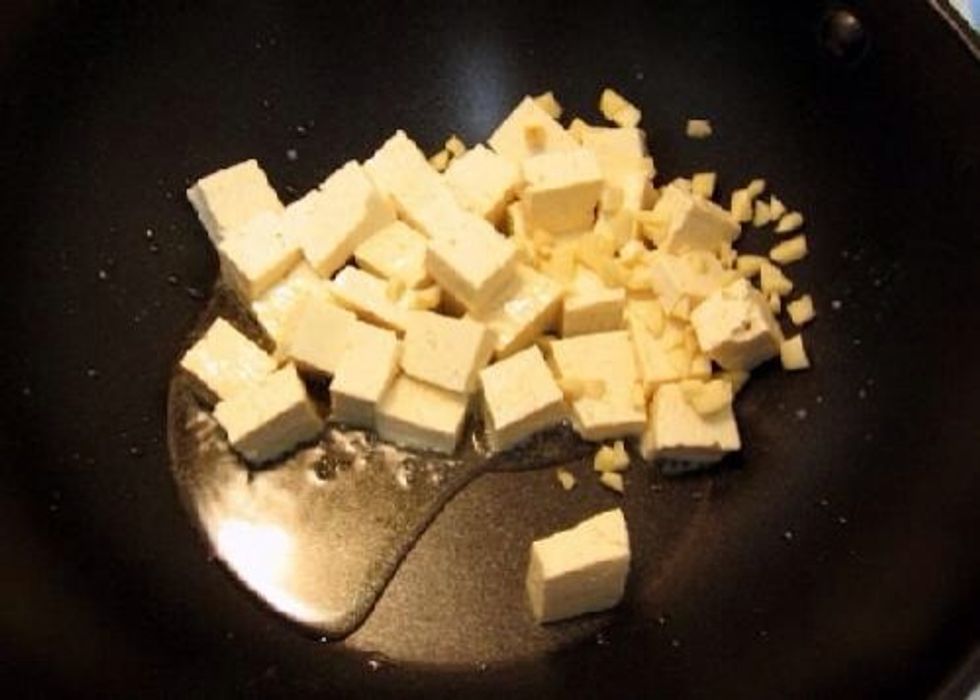 Put tofu and garlic into wok and add 1 tbs rice wine and 2 tbs rice vinegar and keep stirring
