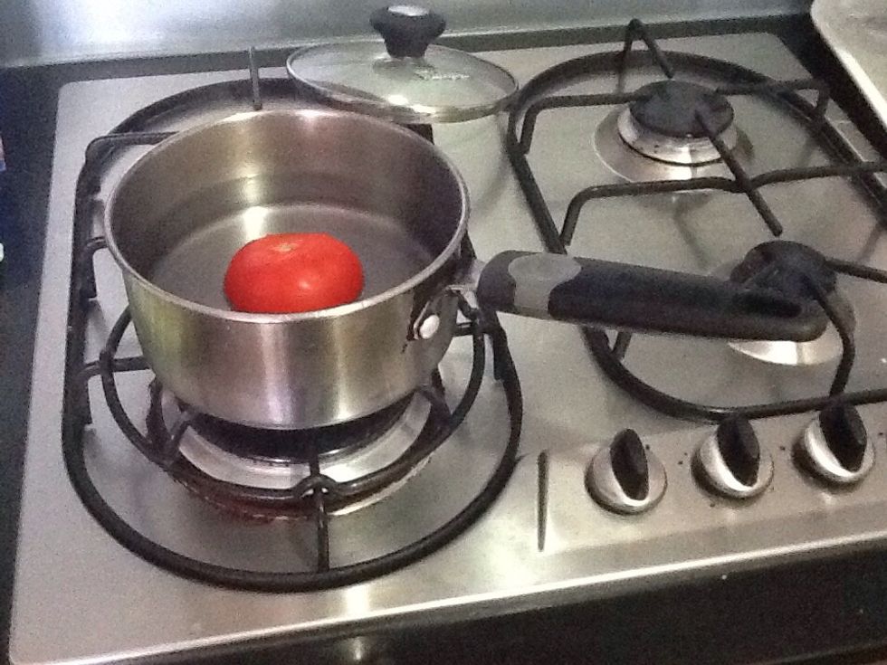 Put tomato in saucepan and add water. We do this so the skin of the tomato can be peeled off easily.