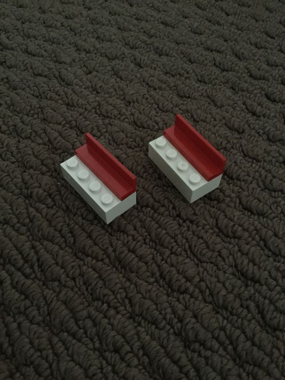 Put two red curved pieces on top of two of the white eight pieces.