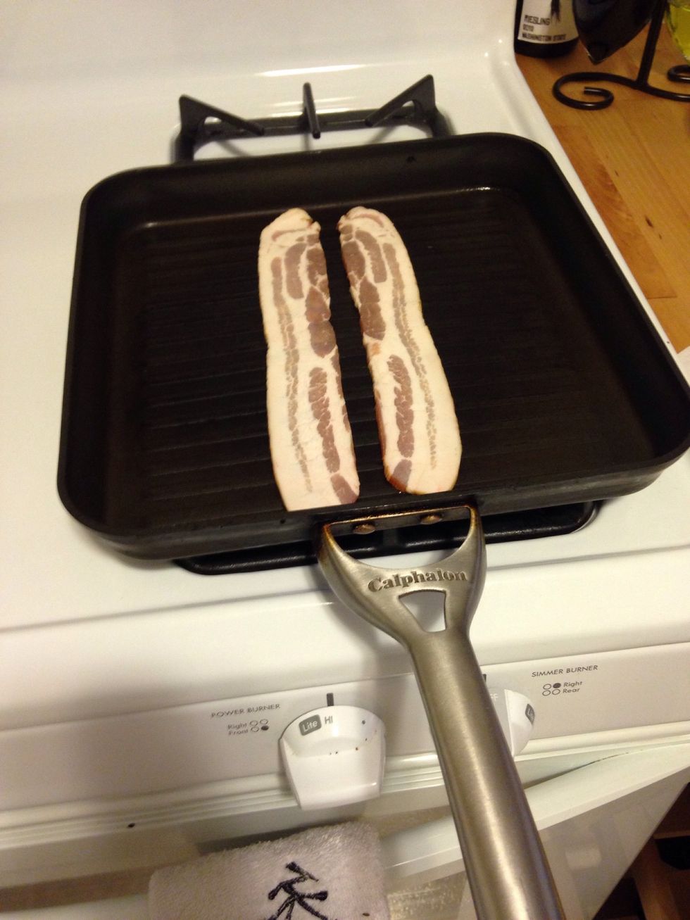 Put two slices of bacon in a pan on high heat.