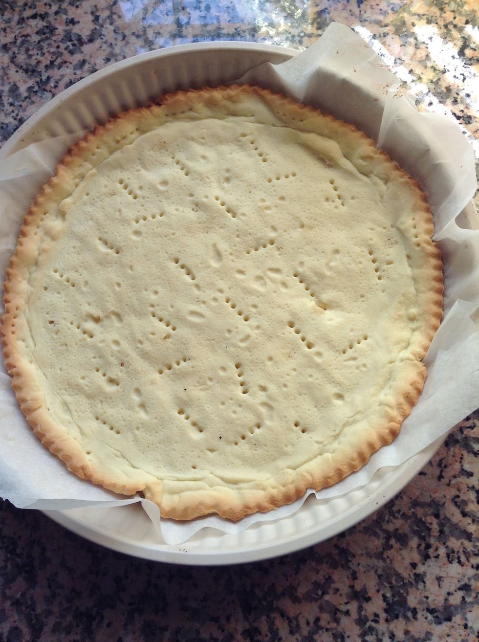Put your cake into the oven at 180\u00ba C and bake it for 12 minutes; then take off the beans-covered parchment paper and bake your base for 5 minutes.