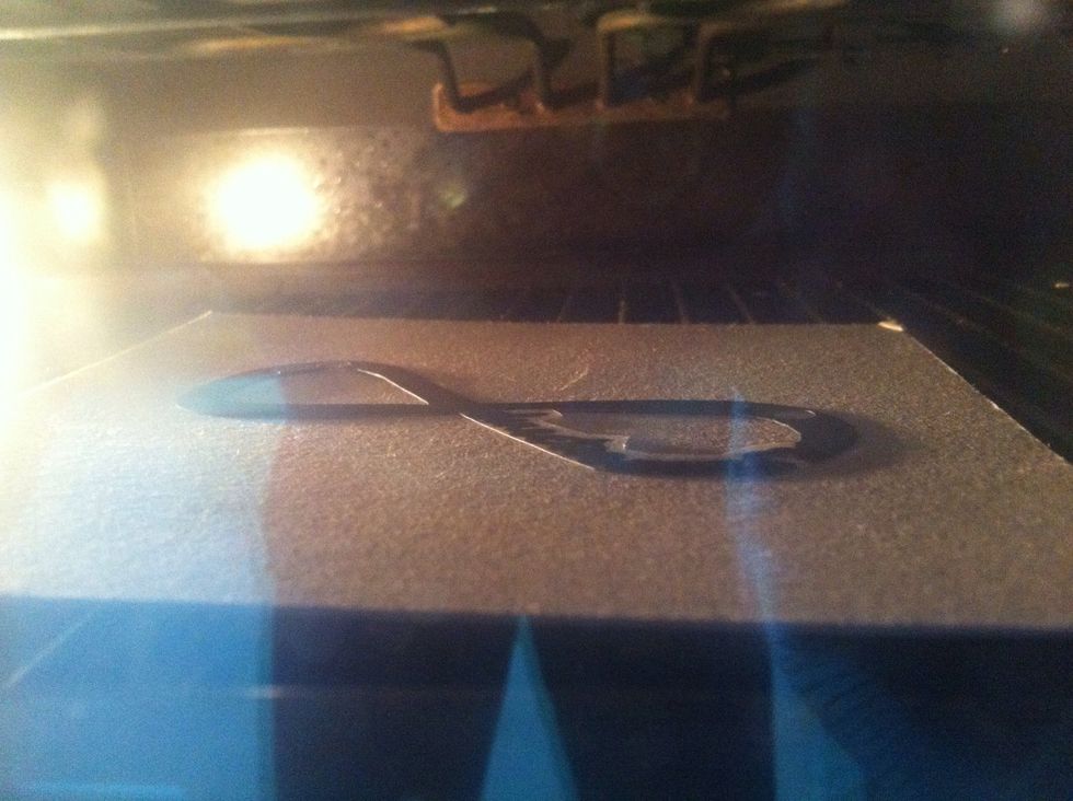 Put your charm on a square of cardboard and into the oven (160'C). Wait for it to shrink! It should take about 30seconds. Leave in the oven for about two minutes, and then take it out to cool.