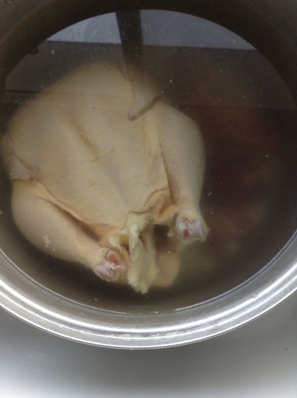 Put your chicken into the water. (Make sure you've removed the giblets from inside the chicken cavity!)