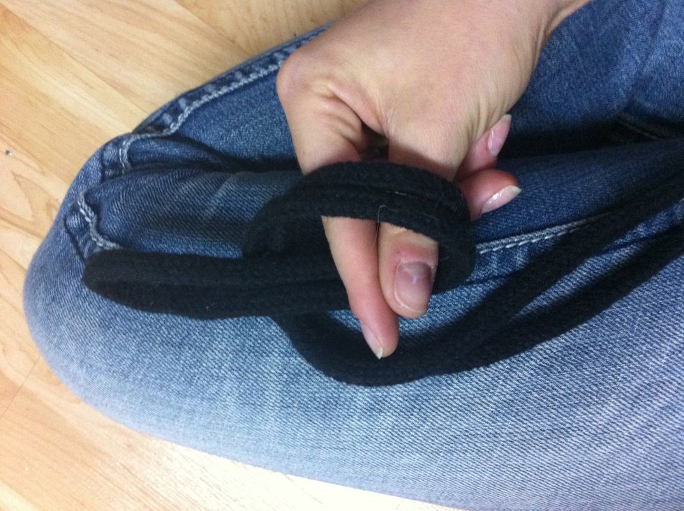 Put your fingers through the loop you created (from behind) and grab onto the rope laying flat, pull through and this will create a new loop. Do not pull the ends though!