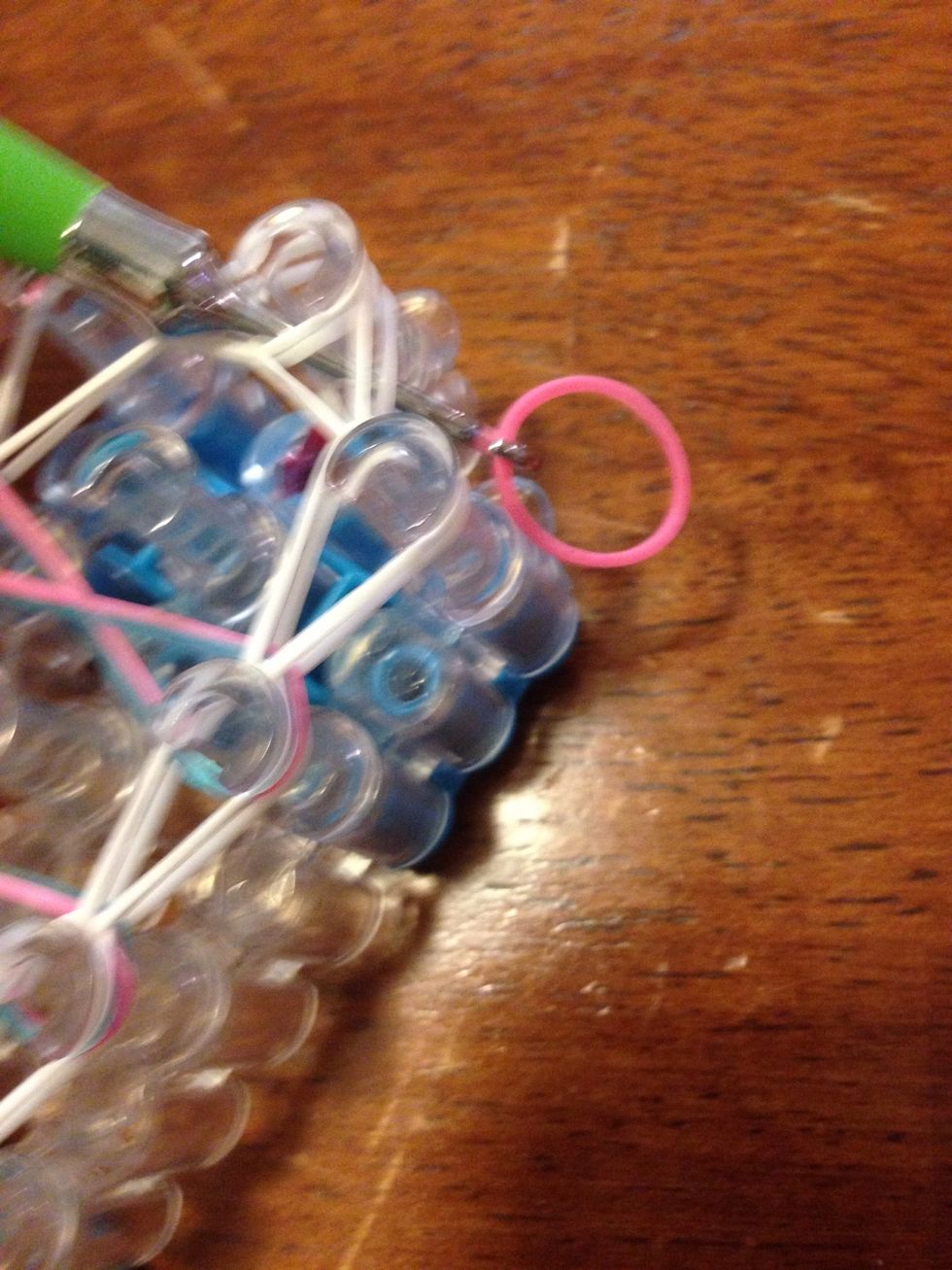 Put your hook in all of the bands on the top pin, then get a band and put it on your hook.