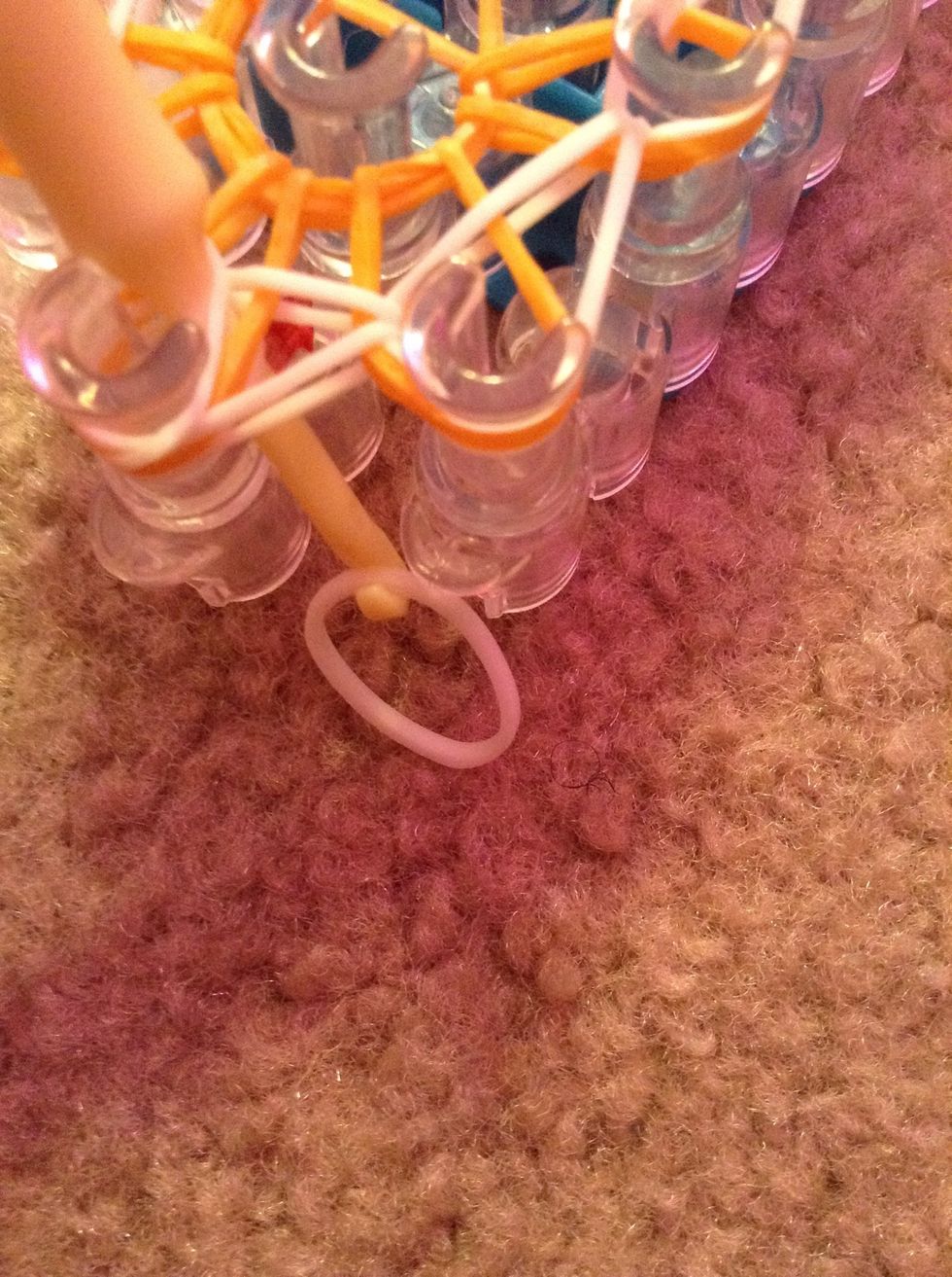 Put your hook in all of the rubber bands and get another rubber band and put it on the hook and pull it while you have it in your finger.