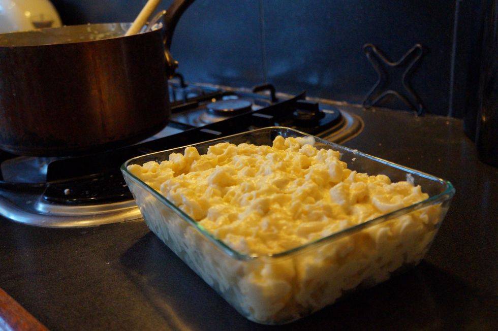 Put your mac and cheese into a glass tray that is safe to go into the oven