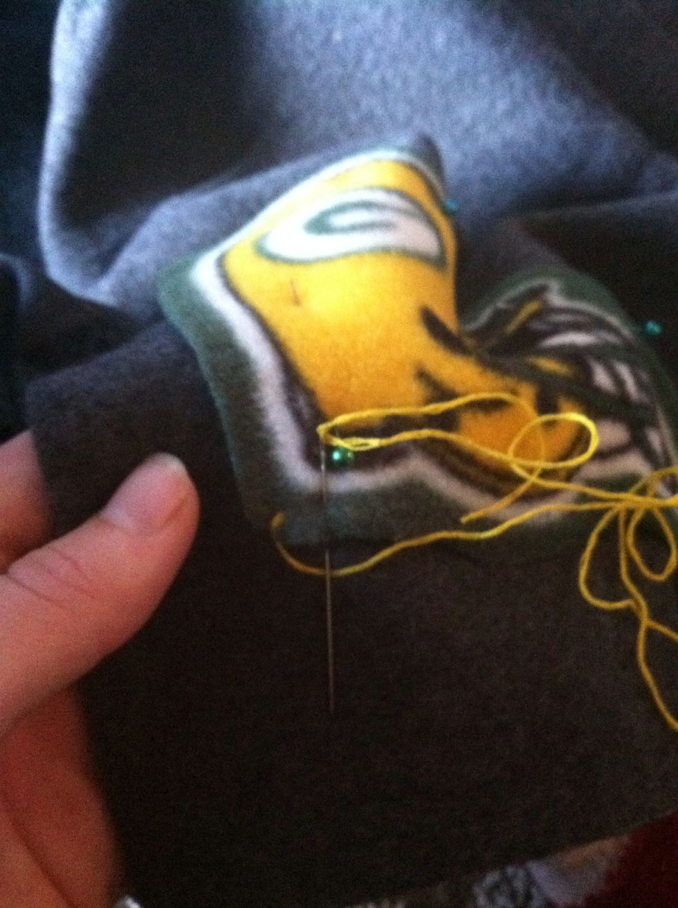 Put your needle down about 3/8" to the right (or left, if you're going to the left) and back up under the edge of the appliqu\u00e9. Make sure your needle is ABOVE the thread.